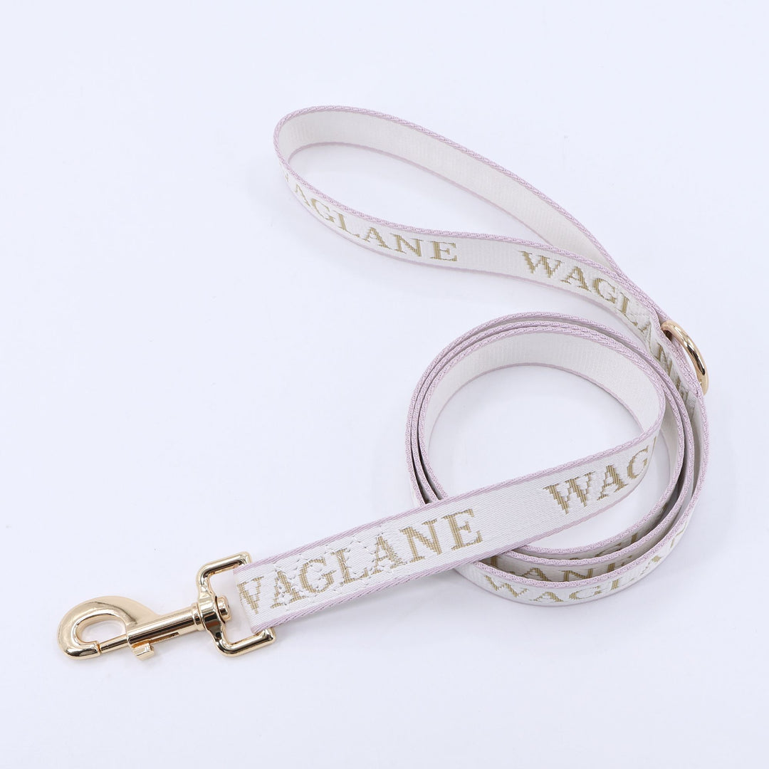 Creme webbing leash with tan jacquard 'WAGLANE' branding and gold hardware