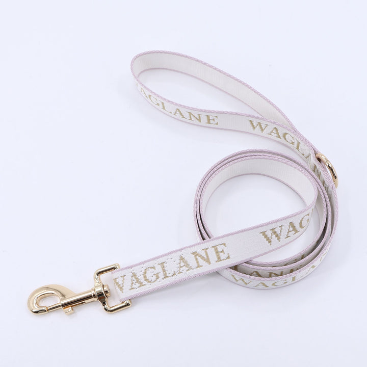 Creme webbing leash with tan jacquard 'WAGLANE' branding and gold hardware