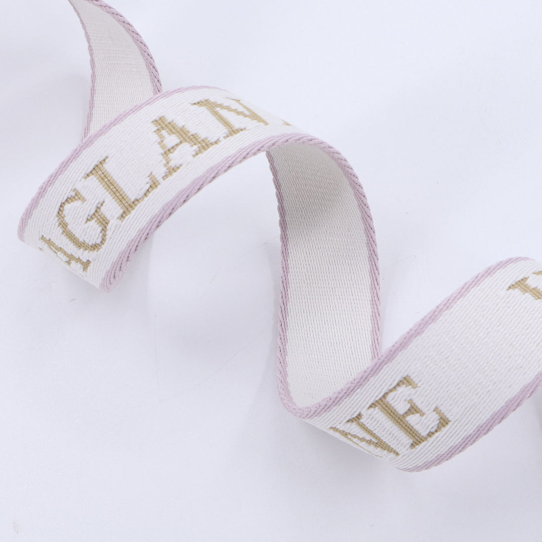 Close-up of luxury woven leash with pale pink edges and tan “WAGLANE” text on a white background, curled in an elegant loop for product branding.